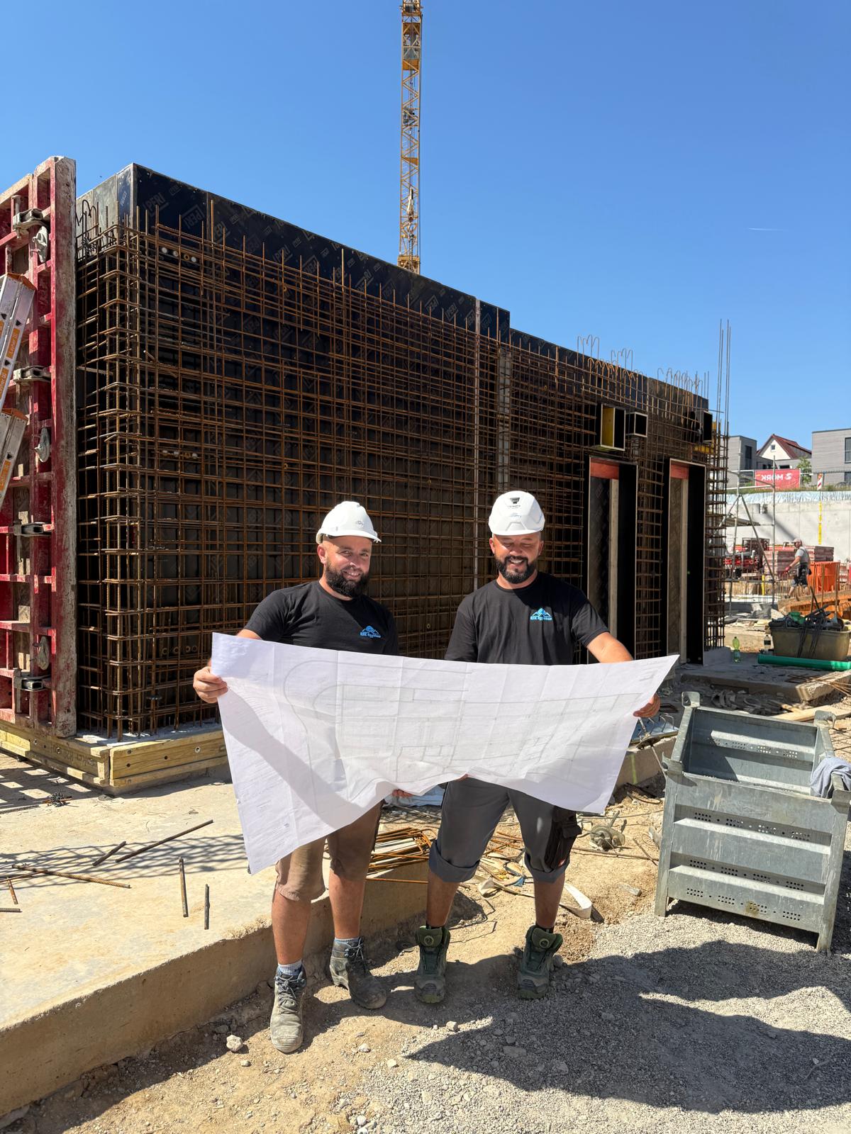 Bauleiter der RSK Hochbau GmbH besprechen Baupläne auf der Baustelle